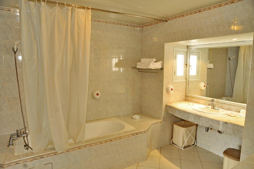 une salle de bain avec une baignoire, une douche et un lavabo dans l'établissement El Pueblo Tamlelt, à Agadir
