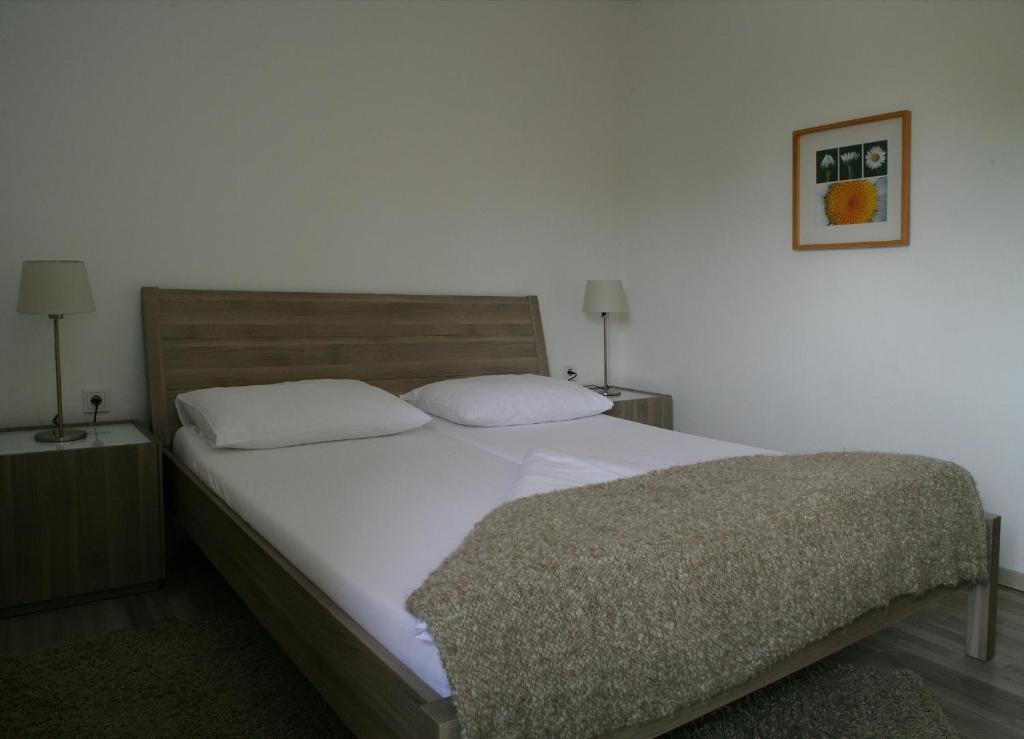 ein Bett mit weißer Bettwäsche und Kissen in einem Schlafzimmer in der Unterkunft Landhaus Tauber in Wallern im Burgenland