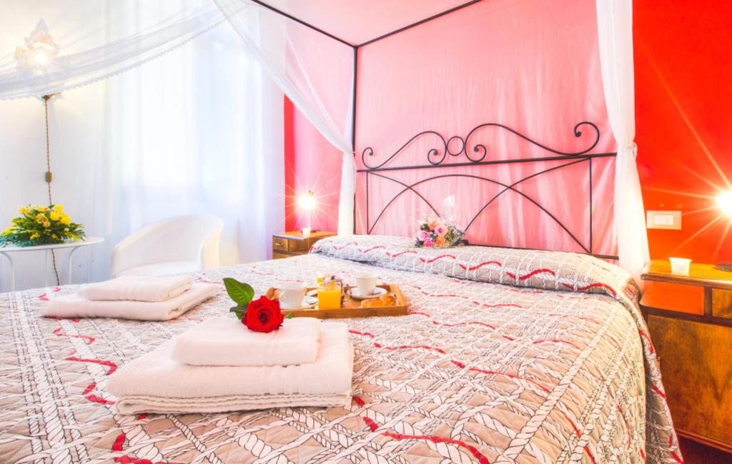 - une chambre avec un lit rose et des serviettes dans l'établissement Locazione Turistica Corte Vecchia, à Venise