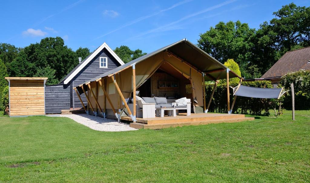 ein Haus mit einer Veranda mit einem Pavillon in der Unterkunft Safaritent in Oostvoorne