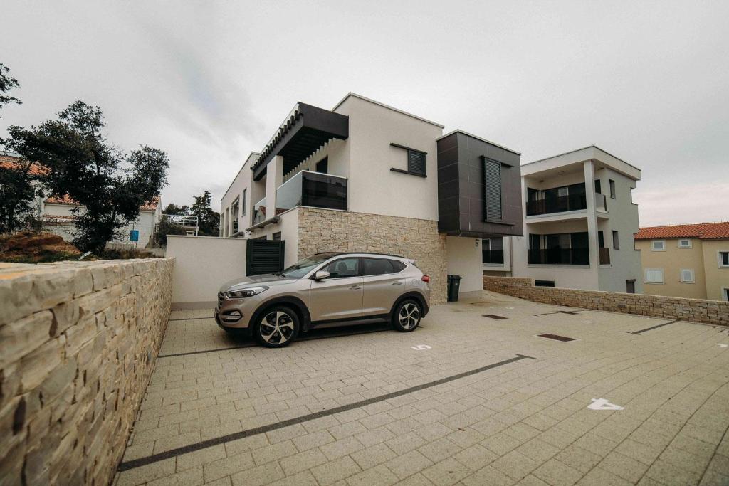 a small car parked in front of a house at Apartment Eveline in Petrcane