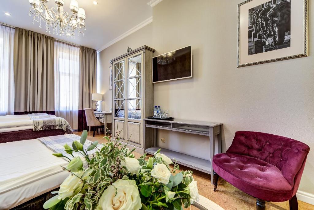 a hotel room with a bed and a purple chair at Pushka INN hotel in Saint Petersburg