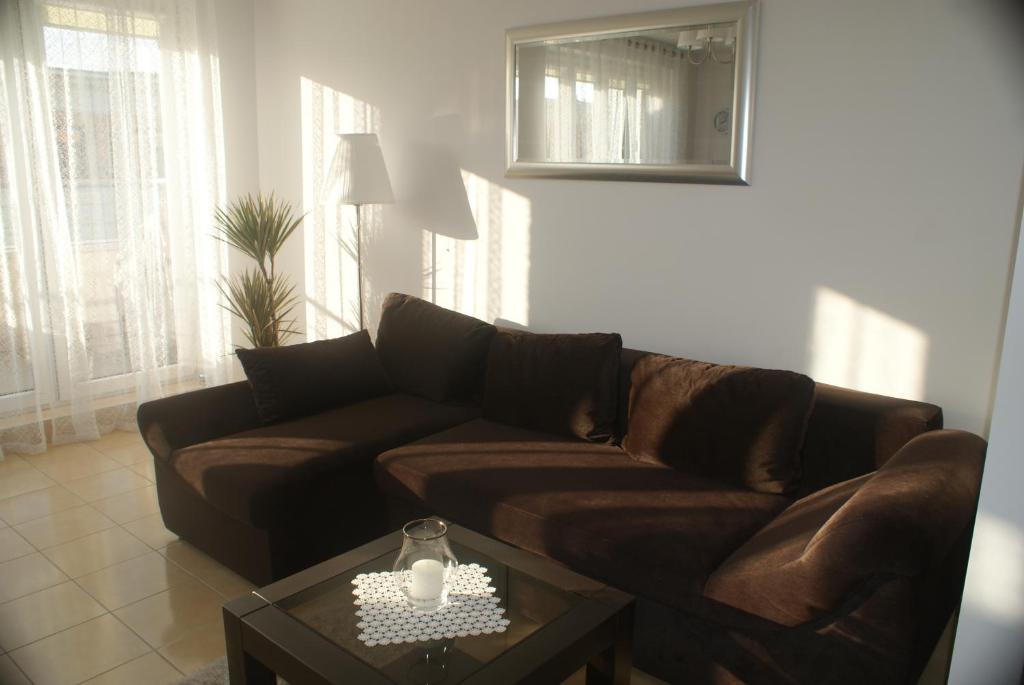 a living room with a brown couch and a table at Apartament Halina in Kołobrzeg