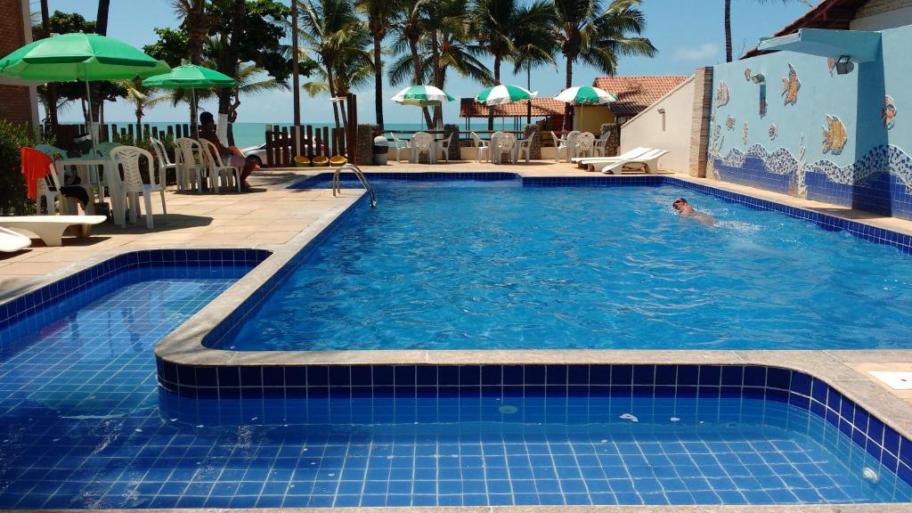 una persona nadando en una piscina en San Bernardo Apart-Hotel, en Alcobaça
