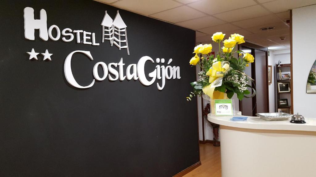 ein Schild für ein Krankenhaus-Cocktail-Fitnessstudio an der Wand in der Unterkunft Hostel Costa Gijon in Gijón