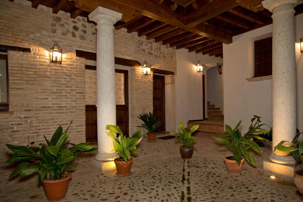 a courtyard with potted plants in a building at Elements Rooms in Toledo