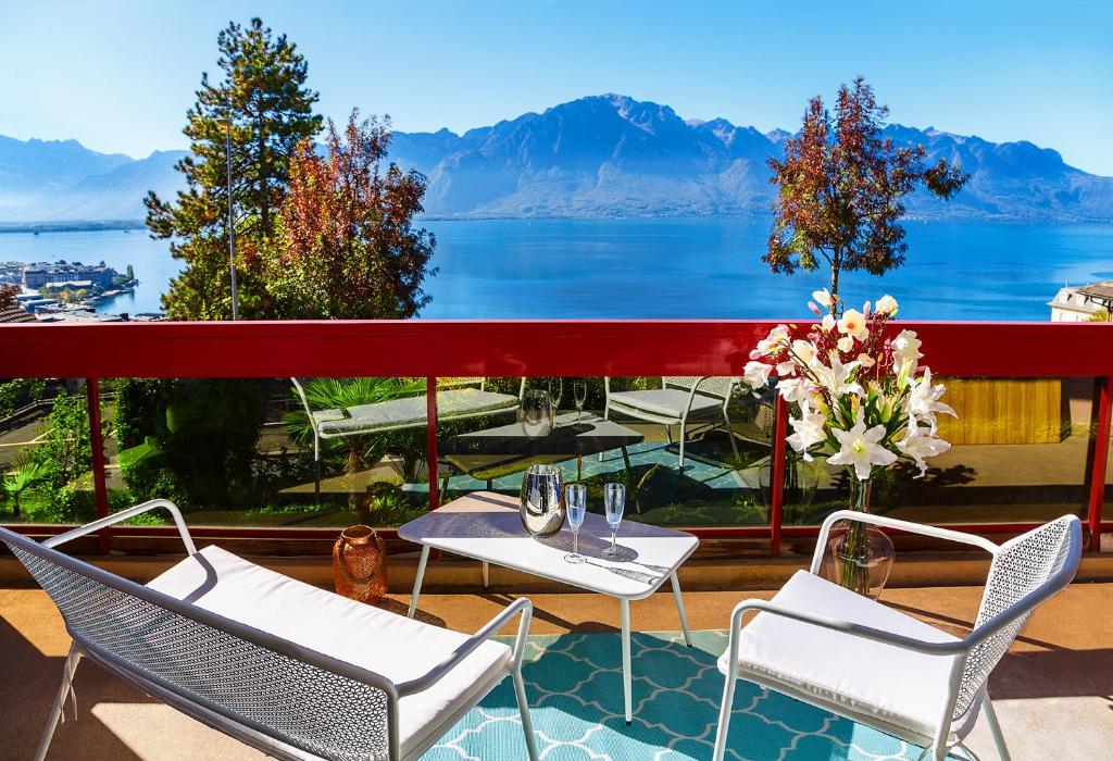 a balcony with chairs and tables and a view of the water at Studio with Lake View in Montreux