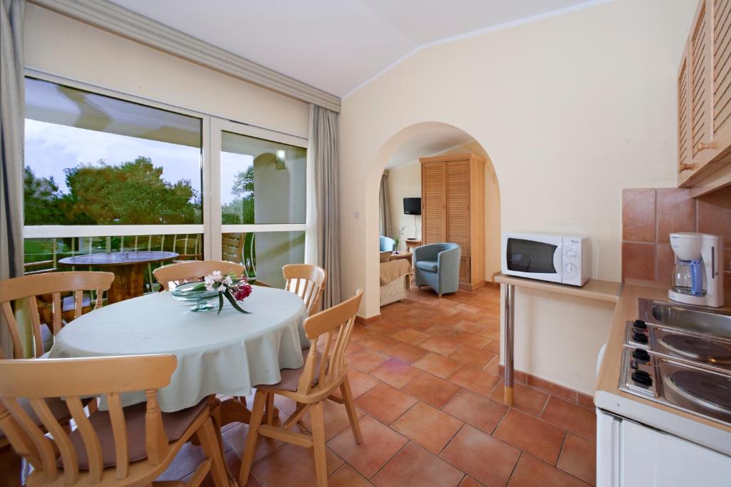 a kitchen and dining room with a table and chairs at Apartments Bellevue Plava Laguna in Poreč