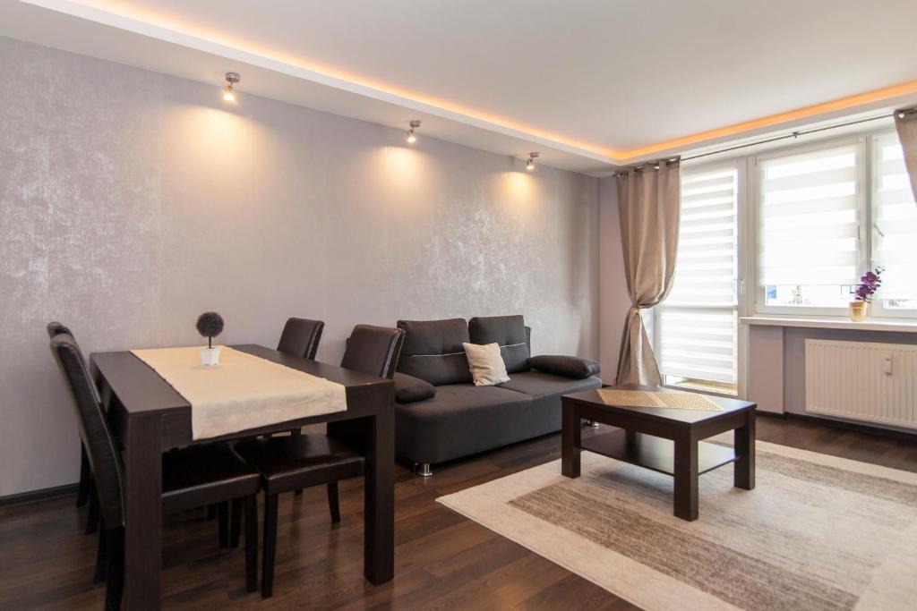 - un salon avec un canapé et une table dans l'établissement Pałacowa Condominium, à Białystok