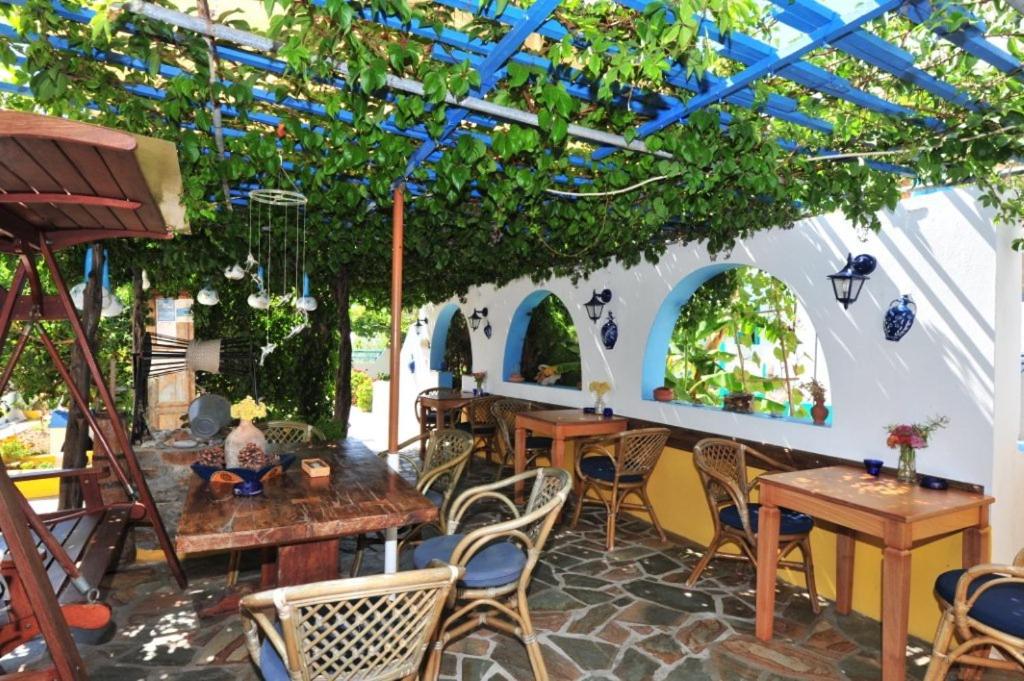 a patio with tables and chairs under a pergola at Pension Titika in Katapola