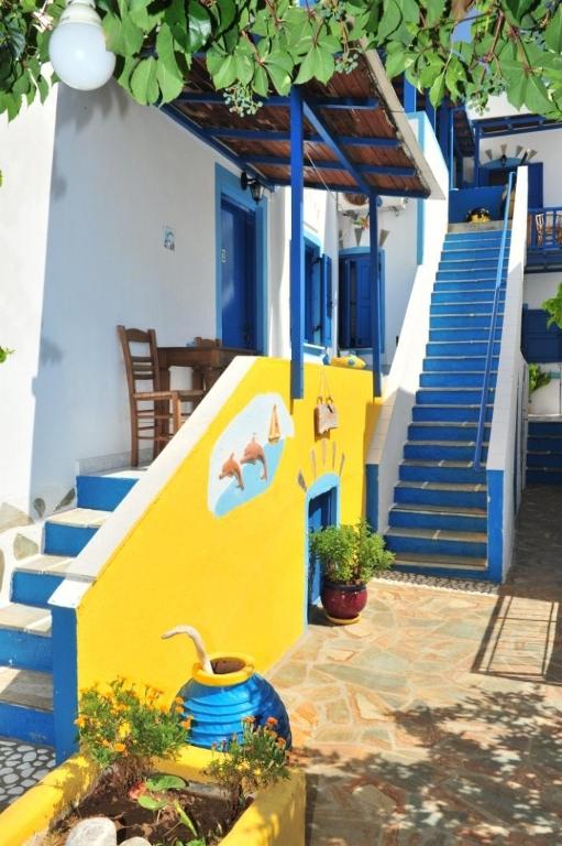 a yellow and blue building with stairs and a stair case at Pension Titika in Katapola