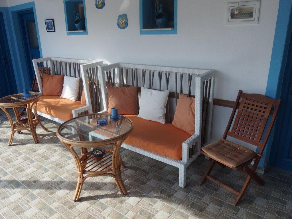 a living room with a couch and a glass table at Pension Titika in Katapola