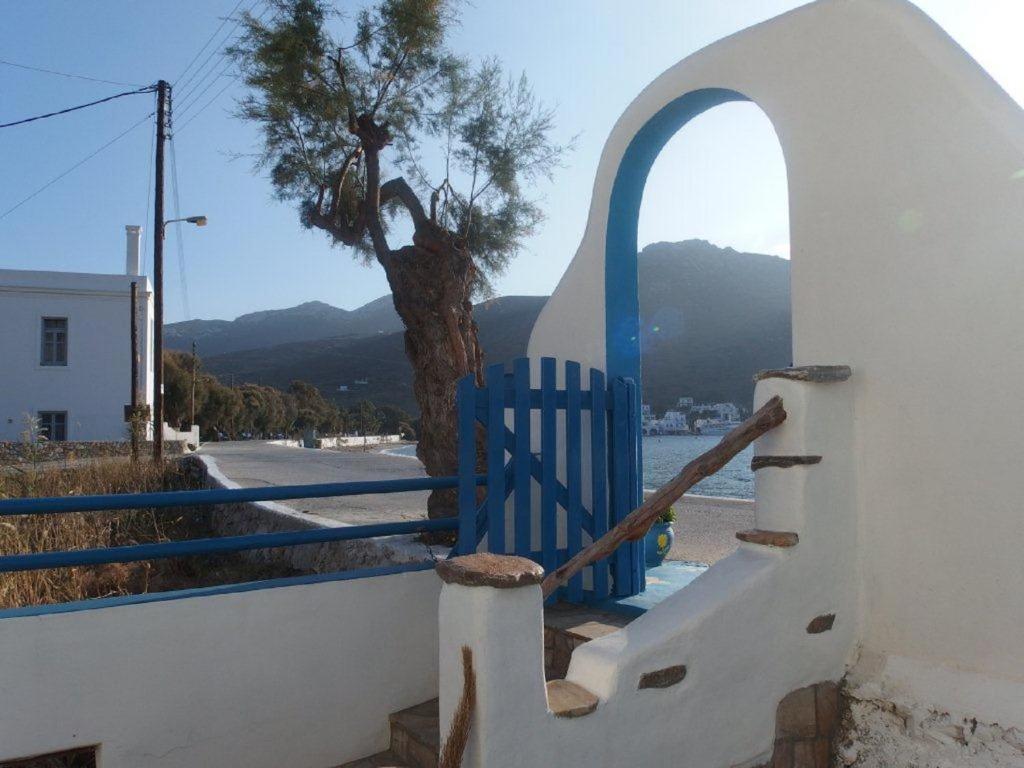 a blue gate in front of a tree at Pension Titika in Katapola