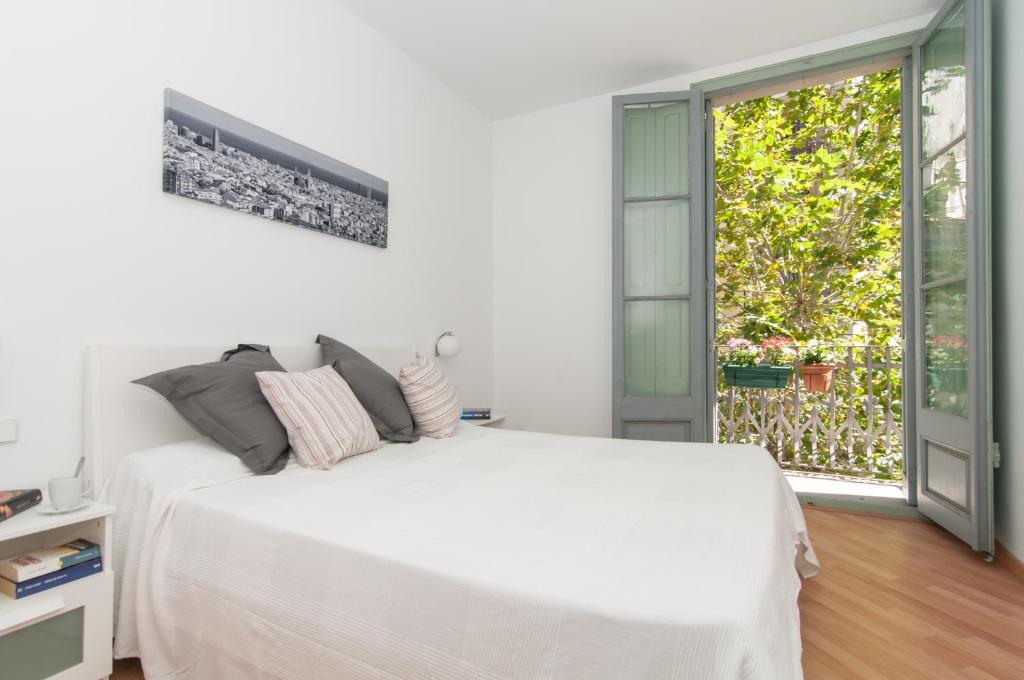 バルセロナにあるMontaber Apartment - Sant Antoniの白いベッドルーム(白いベッド1台、窓付)