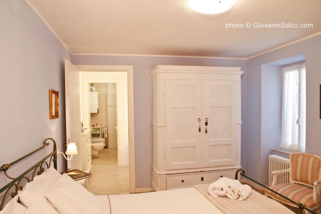 a bedroom with a bed and a hallway with a mirror at Casa Azzurra in Menaggio