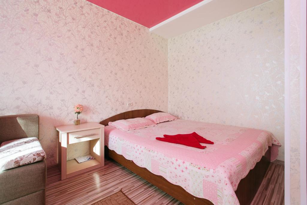 a bedroom with a bed with a red shirt on it at Apartamenty Svetlica Krylova 69a in Novosibirsk