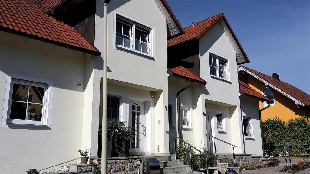 eine Reihe weißer Häuser mit roten Dächern in der Unterkunft "Villa Sabine" in Waidhaus