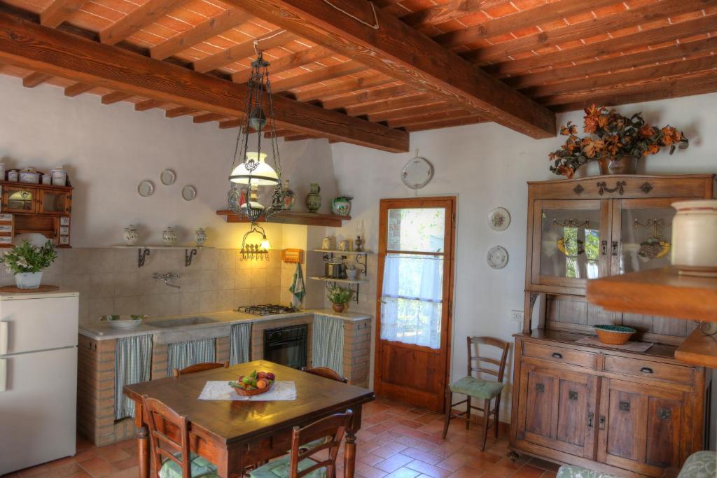 una cucina con armadi in legno, tavolo e tavolo di La Casa Di Nonna Lucia a Montescudaio