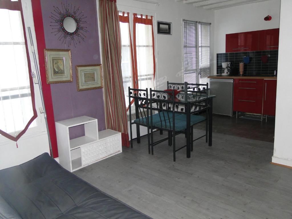 a living room with a table and chairs and a kitchen at Apartment Notre Dame in Paris