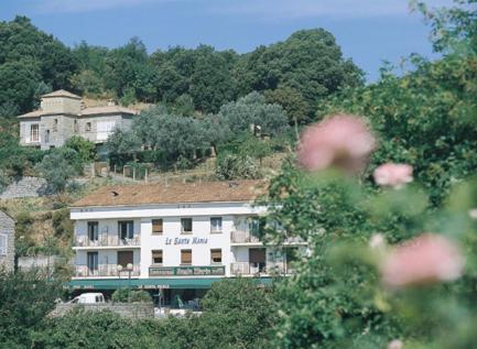 a large white building on a hill with trees at le Santa Maria in Santa-Maria-Siché
