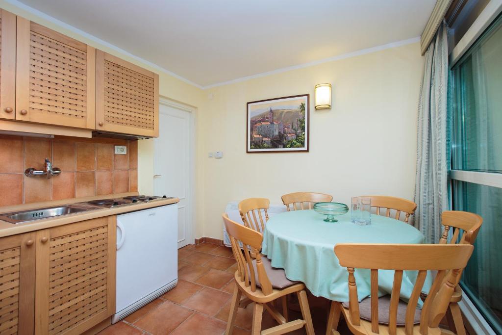 a kitchen with a table and chairs in a room at Apartments Bellevue Plava Laguna in Poreč