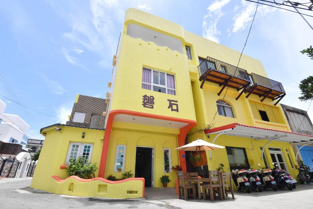 a yellow building with an umbrella in front of it at Rock House in Eluan