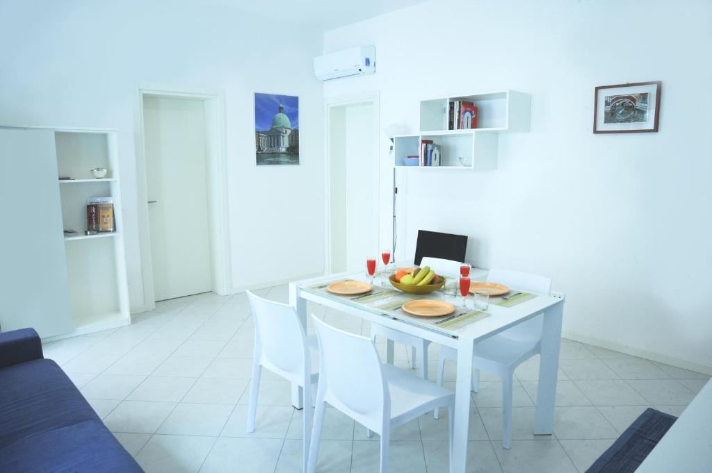 a kitchen with a white table and white chairs at Residenza Ca' Matta in Venice