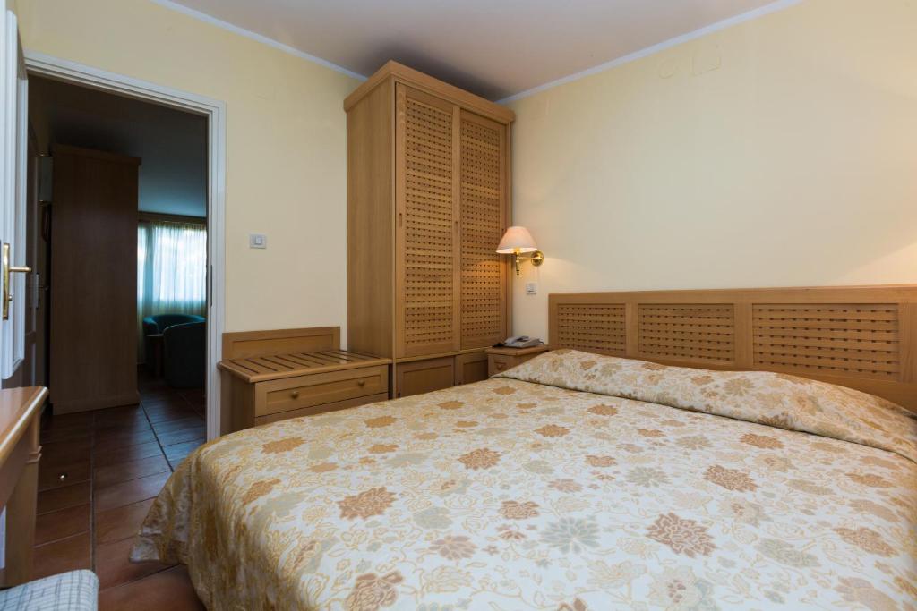a bedroom with a bed and a dresser and a cabinet at Apartments Bellevue Plava Laguna in Poreč
