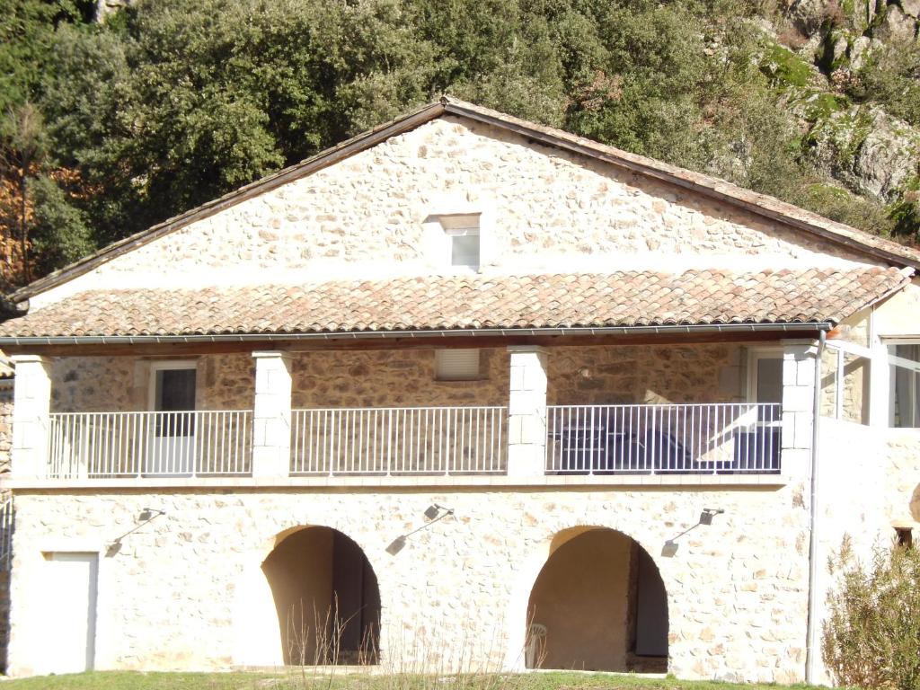 a stone house with a balcony on top of it at la maison de bonneval in Jaujac