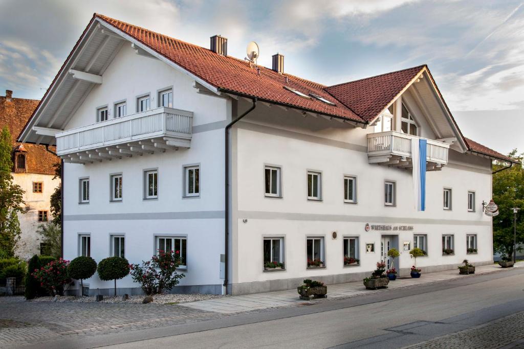 un bâtiment blanc avec un toit rouge dans l'établissement Hotel Wirtshaus am Schloss, à Aicha vorm Wald