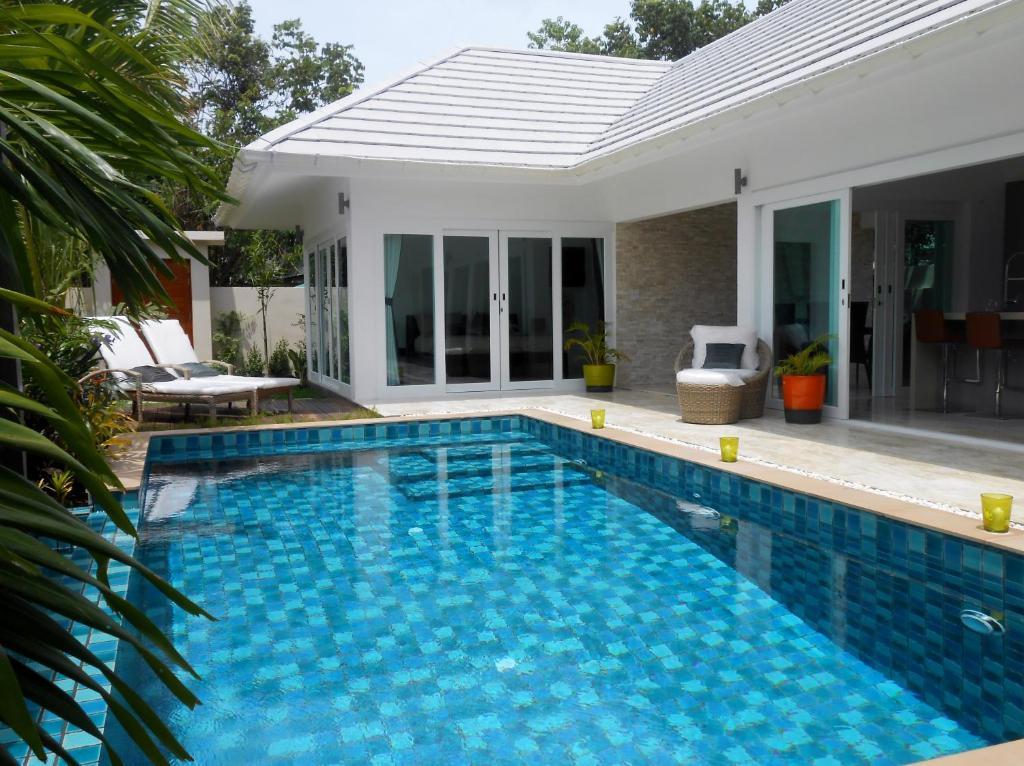 a swimming pool in front of a villa at Baan Tai Tara 4 in Ban Tai