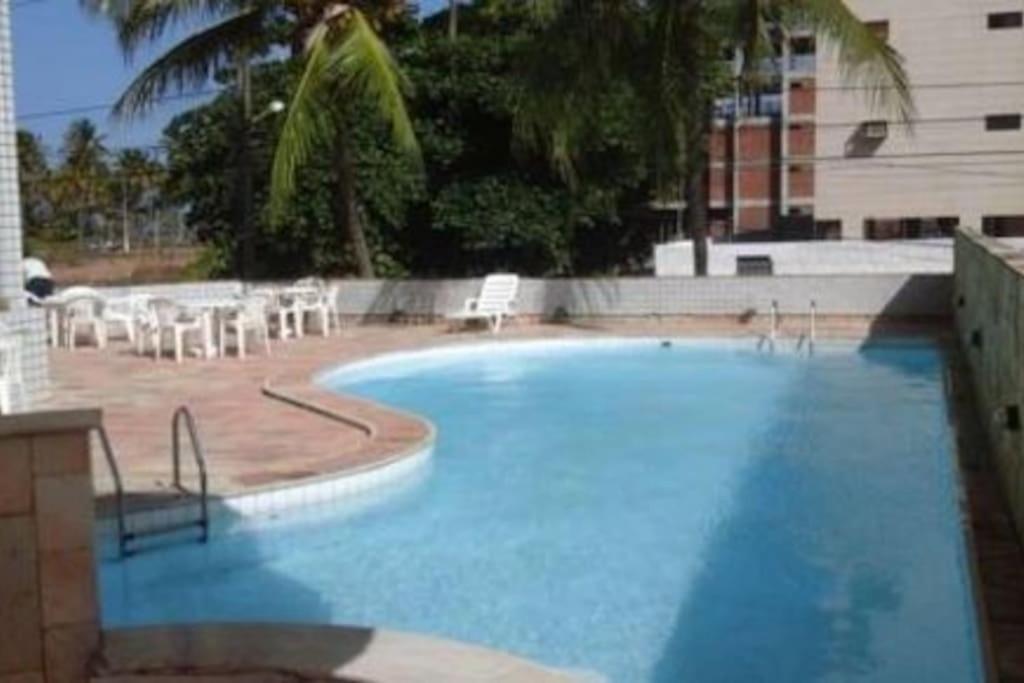 a large blue swimming pool with tables and chairs at Victory Flat Intermares in Cabedelo