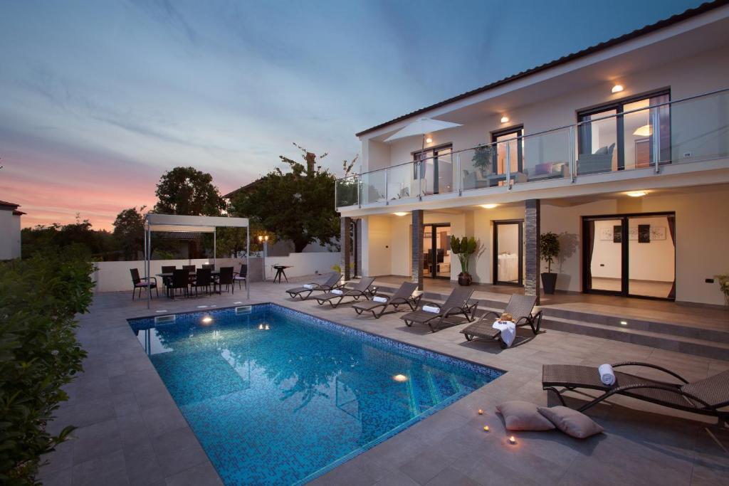 une villa avec une piscine en face d'une maison dans l'établissement Villa Grey Soul, à Medulin