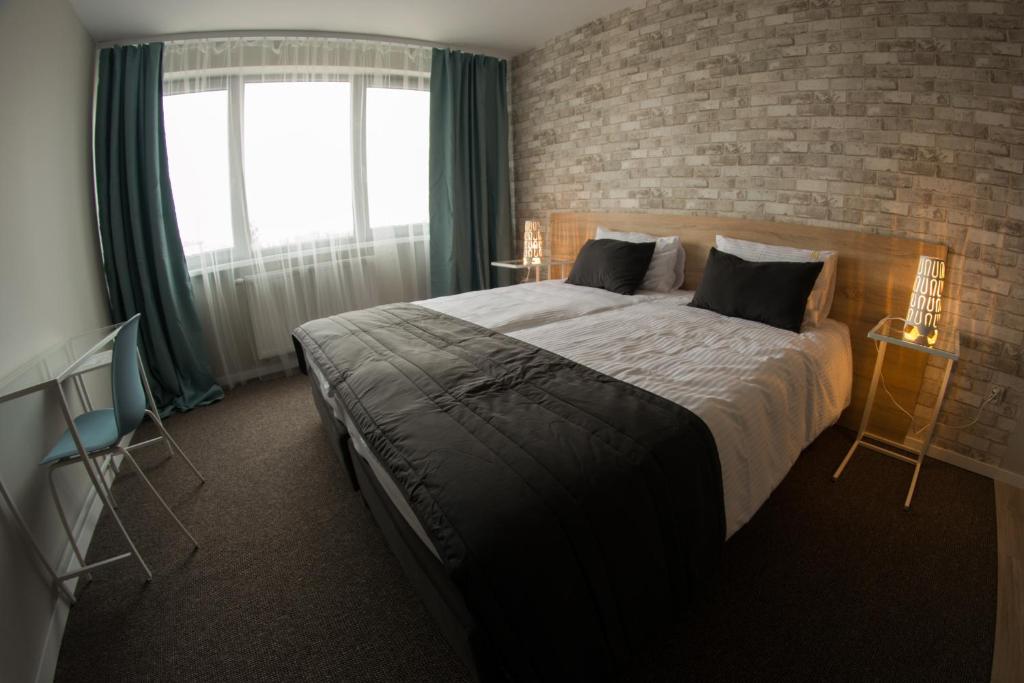 um quarto com uma cama grande e uma parede de tijolos em Życzliwa Centrum Konferencyjno-Sportowe em Breslávia