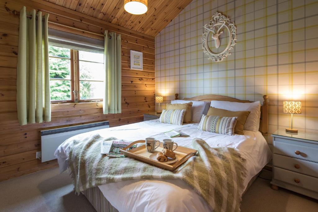 a bedroom with a bed with a tray on it at The Lodges at Artlegarth in Ravenstonedale