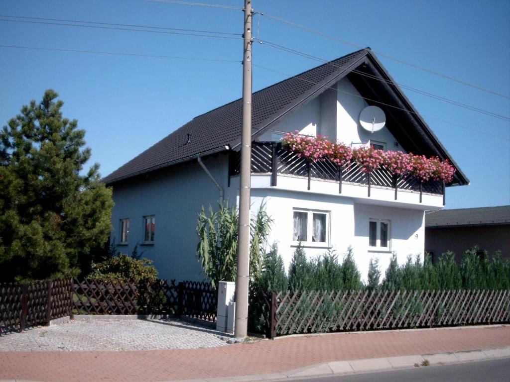 uma casa branca com um telhado preto e caixas de flores em Ferienwohnungen Zeise em Leipzig