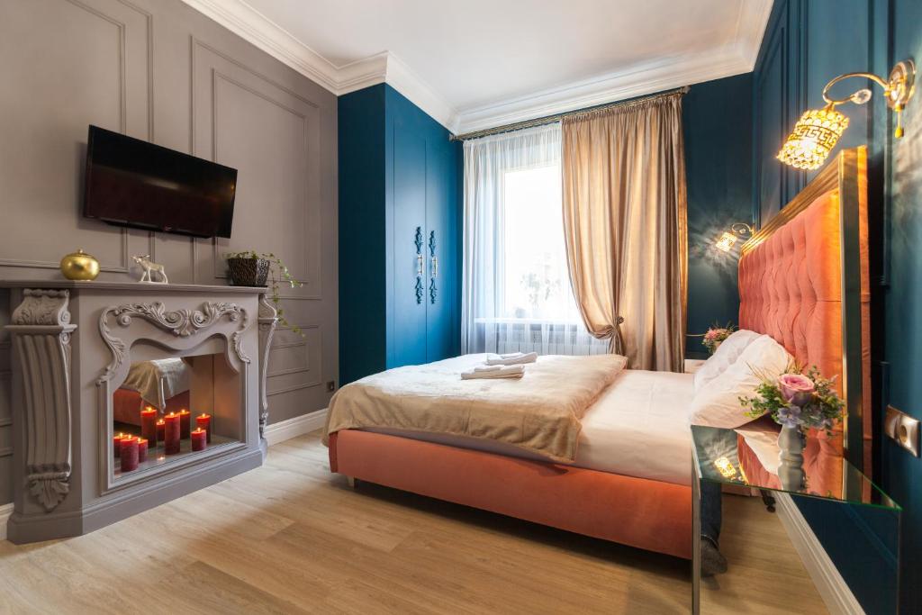 a bedroom with a bed and a fire place at City Center Apartments 2 in Lviv