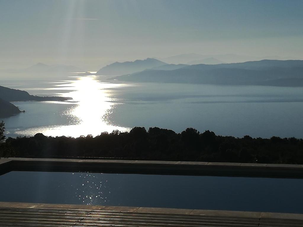 einen Blick auf einen Wasserkörper mit der Sonne am Himmel in der Unterkunft Luxury villa in Kechria in Kechria