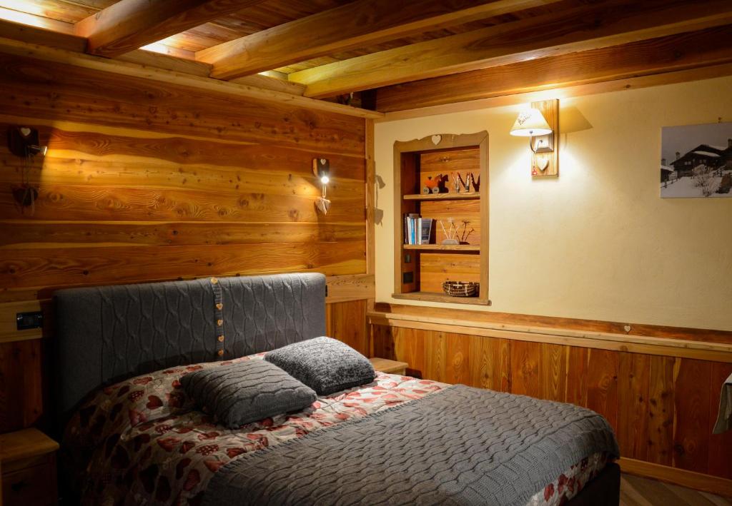 a bedroom with a bed in a room with wooden walls at Au Coin Du Chateau in Châtillon
