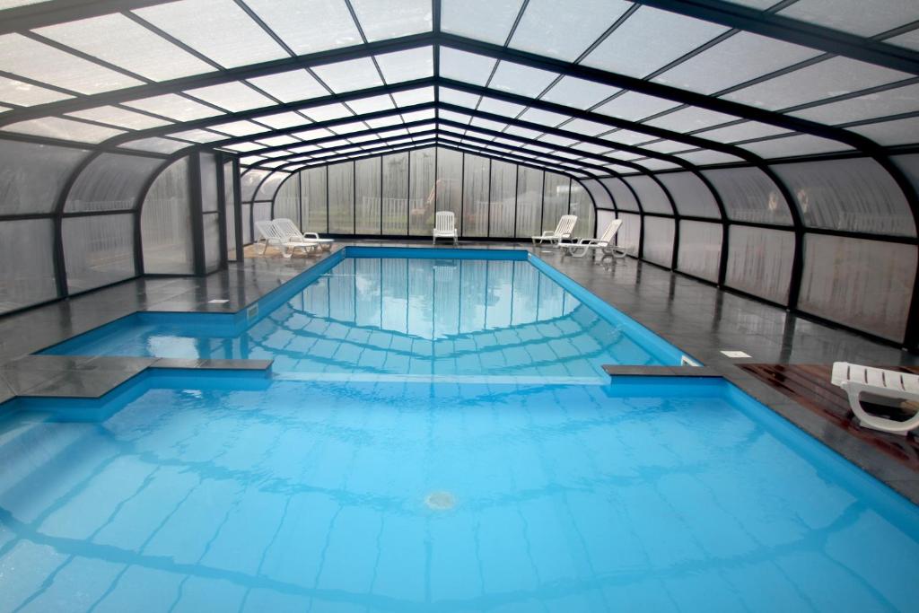 uma grande piscina interior com água azul em Camping La Pindière em Héric