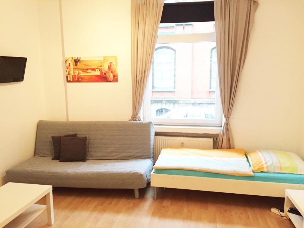um pequeno quarto com uma cama e uma janela em Hannover Südstadt - Zimmer und Apartment em Hanôver