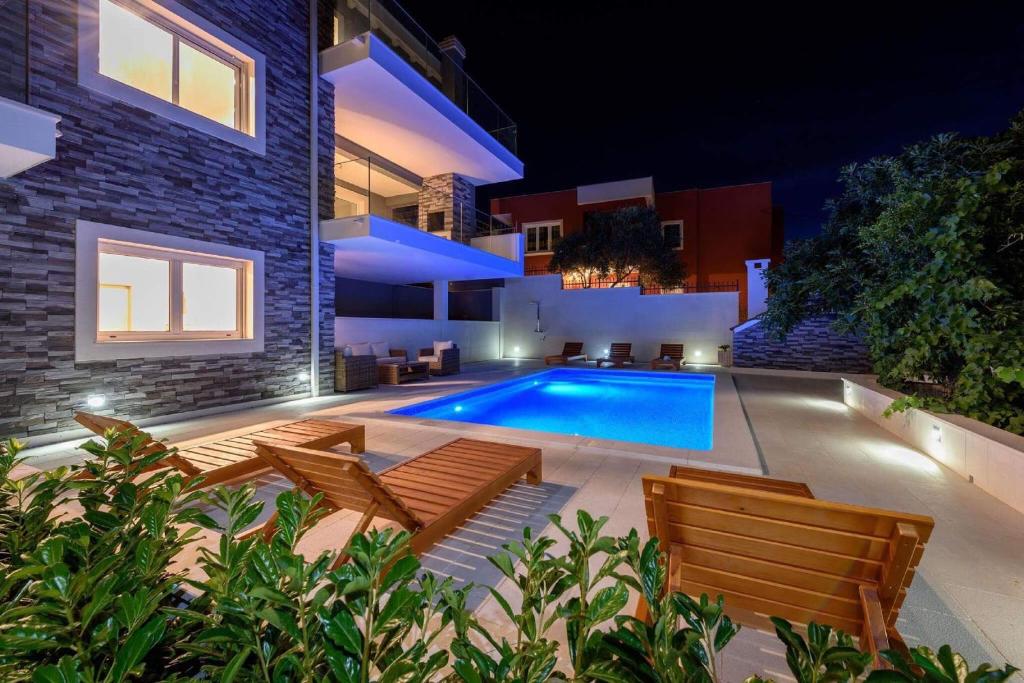 una piscina en el patio trasero de una casa por la noche en Luxury Villa Residence Zupanovic Trogir, en Trogir