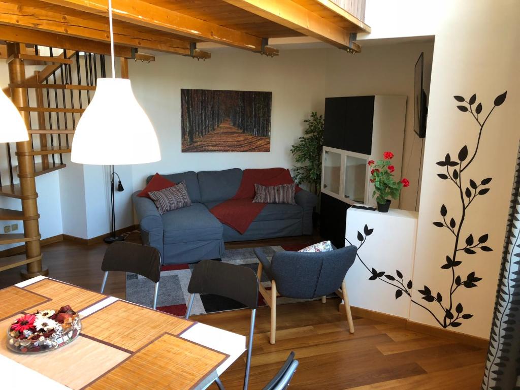 un soggiorno con divano blu e tavolo di Residenza Quarto a Granarolo dellʼEmilia