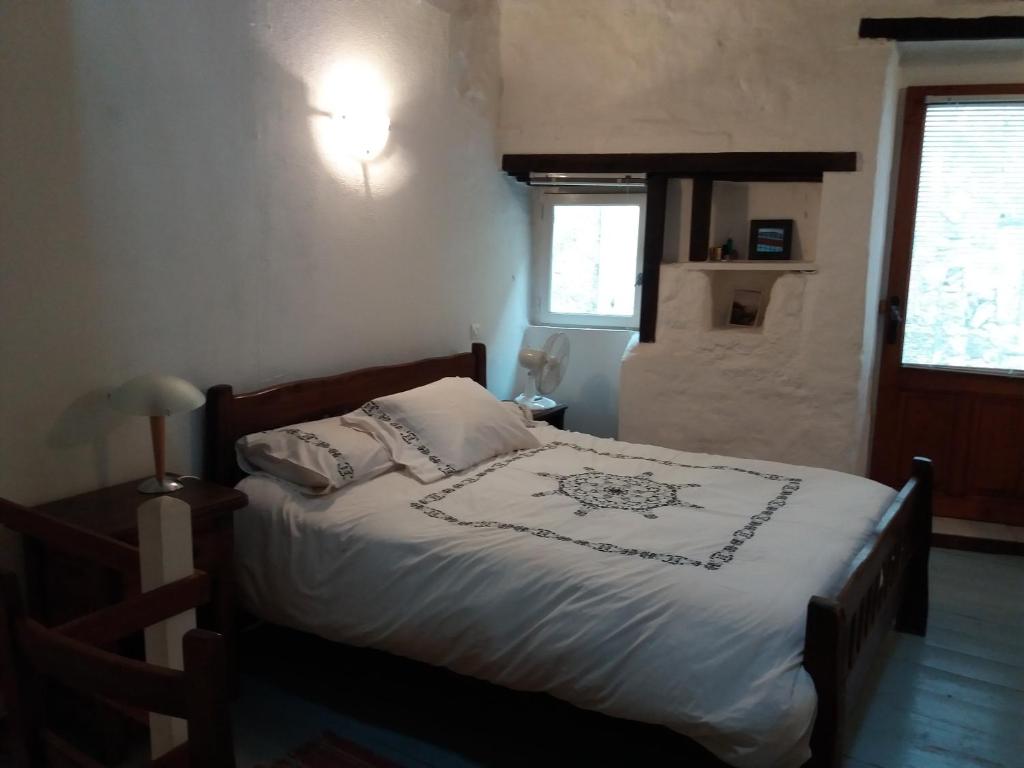 Caunes-MinervoisにあるAnglaiseのベッドルーム1室(白いシーツと枕のベッド1台付)