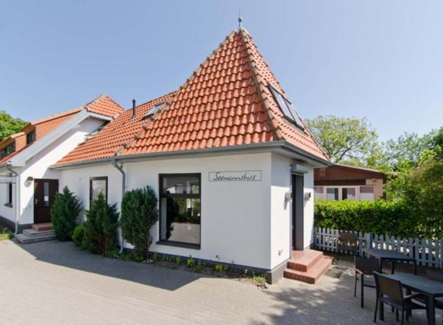 ein kleines weißes Haus mit rotem Dach in der Unterkunft Gästehaus & Restaurant Seemannshus (Pension) in Vitte