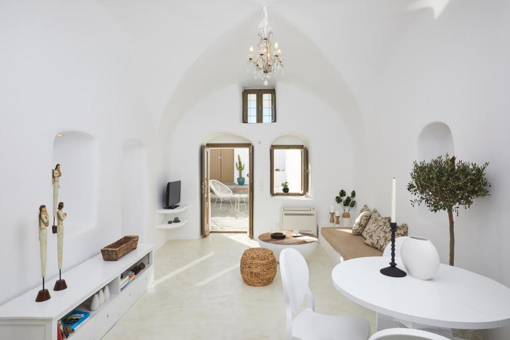 een witte woonkamer met een witte tafel en stoelen bij The Small Architect's House in Pirgos