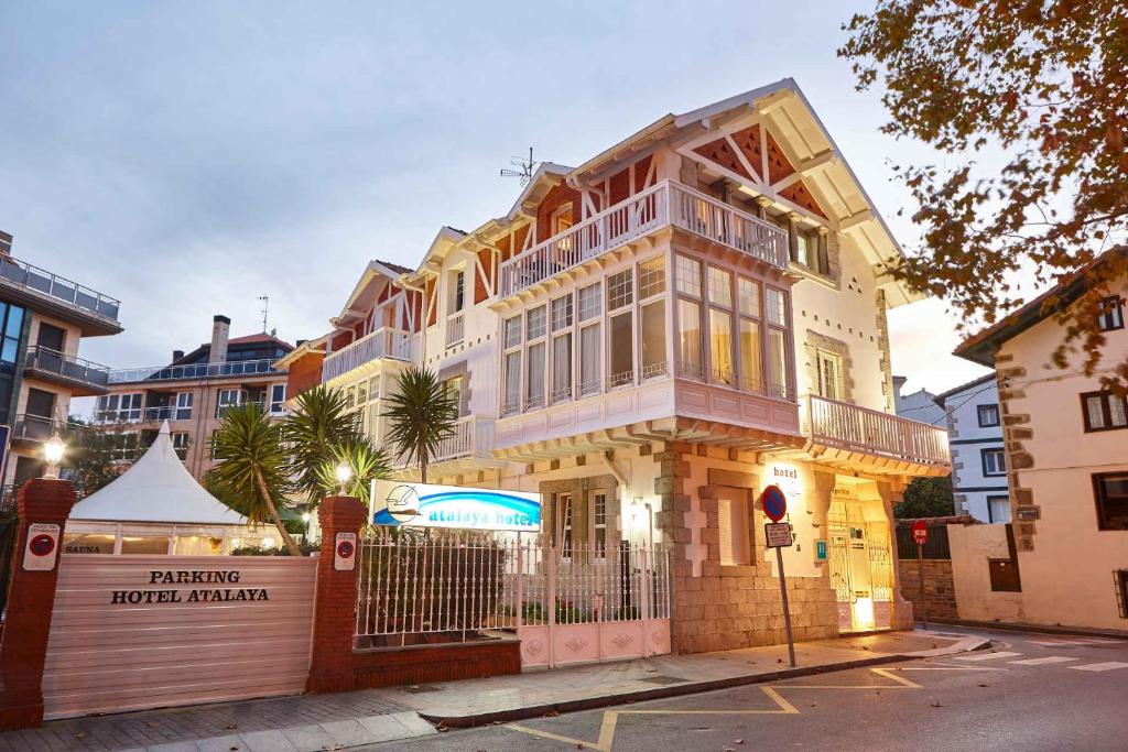 ein großes Haus mit einem Zaun davor in der Unterkunft Hotel Atalaya in Mundaka