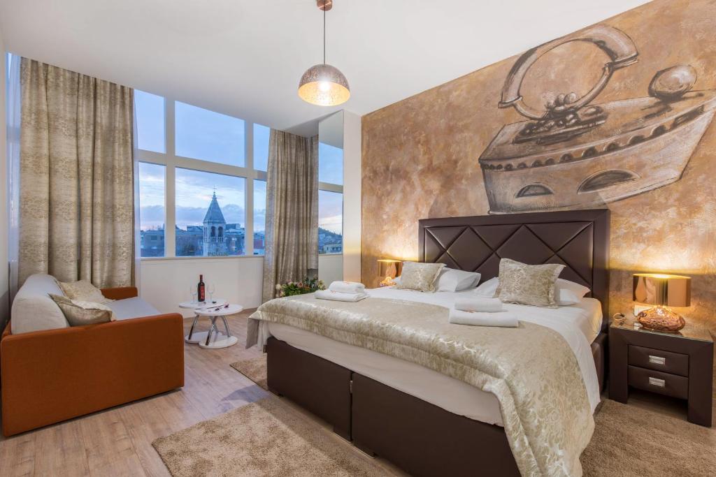 a bedroom with a large bed with a painting on the wall at PRIMA Life Spalato in Split