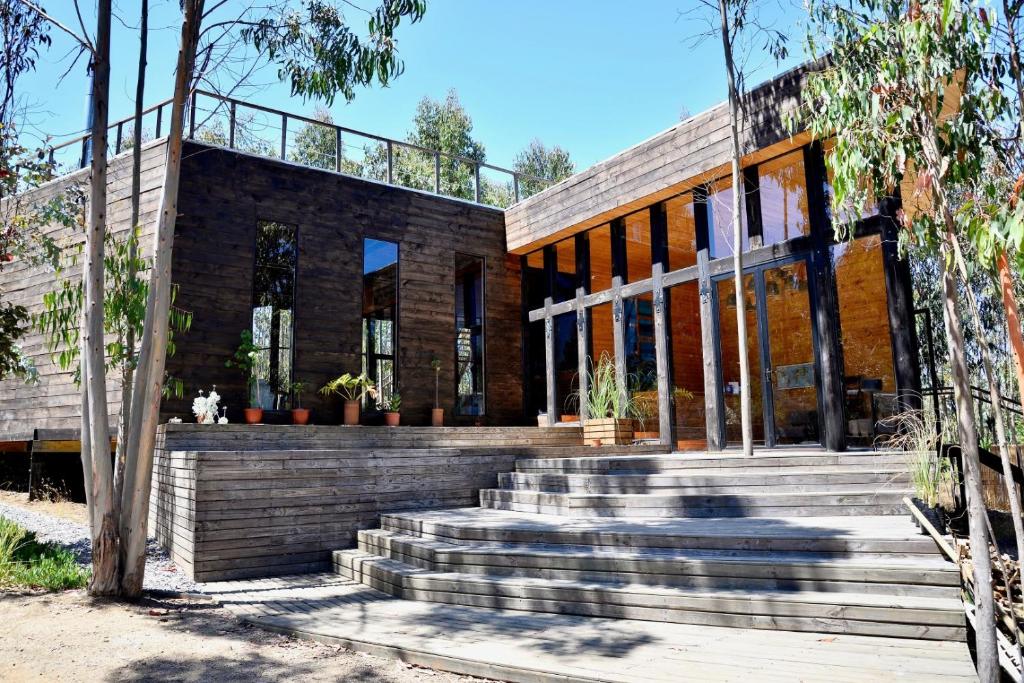 a house with a staircase leading up to it at Tripanko Lodge & Bungalows in Pichilemu