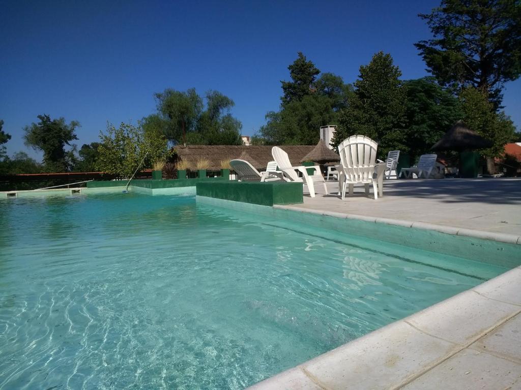 una piscina de agua con sillas y una mesa en Hotel Radio en Valle Hermoso
